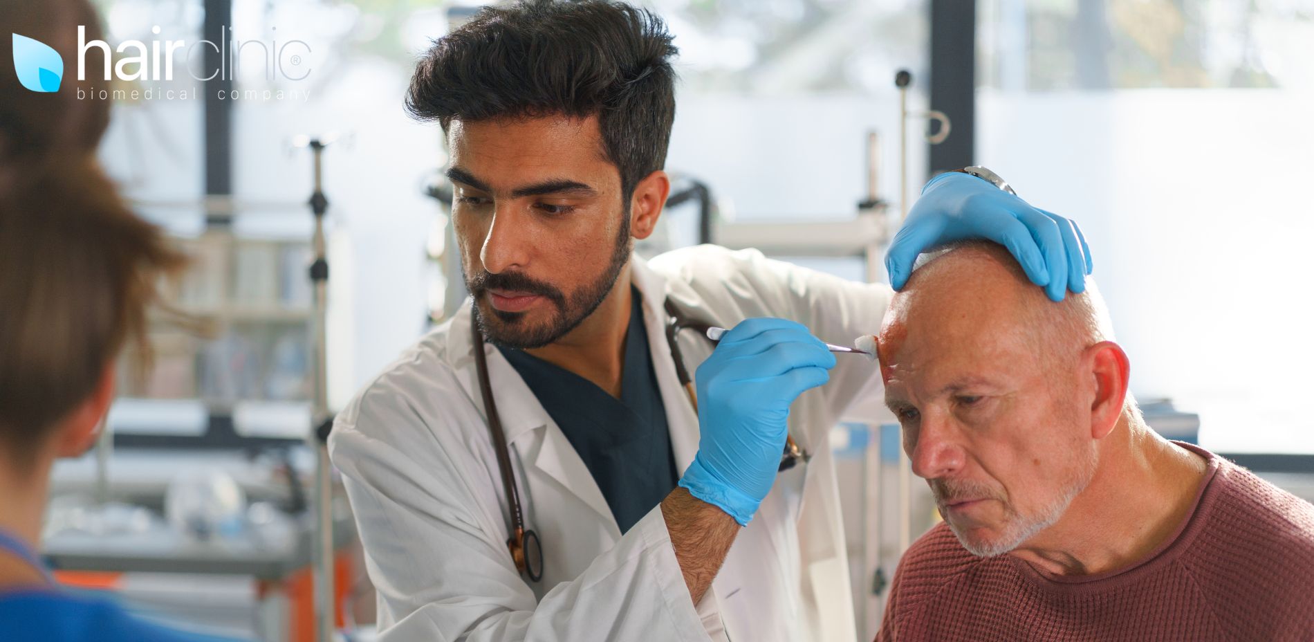 medico cura una ferita alla testa ad un suo paziente