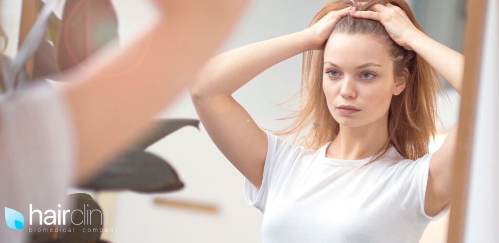 Donna che controlla i capelli allo specchio