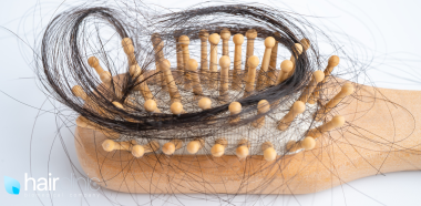 spazzola in legno coperta di capelli scuri e lunghi