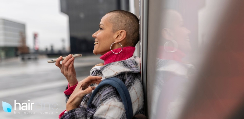 bald woman speaking on the phone